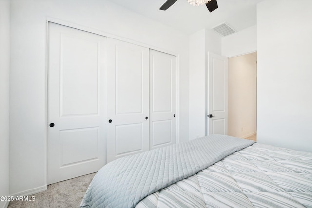 carpeted bedroom featuring ceiling fan and a closet