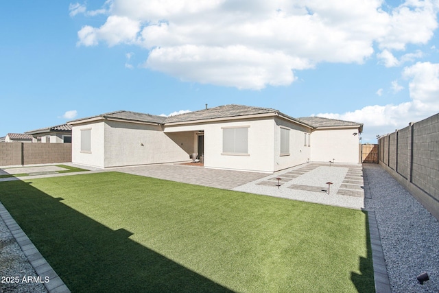 back of property featuring a lawn and a patio area