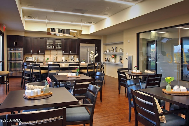 dining space featuring dark wood-type flooring and sink