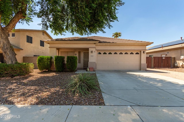 view of front of house with driveway, a tile roof, a garage, and stucco siding