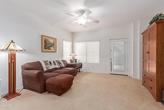 living room featuring a ceiling fan, light carpet, and baseboards