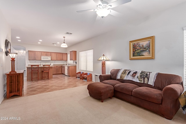 living room with ceiling fan, light tile patterned floors, recessed lighting, light carpet, and visible vents