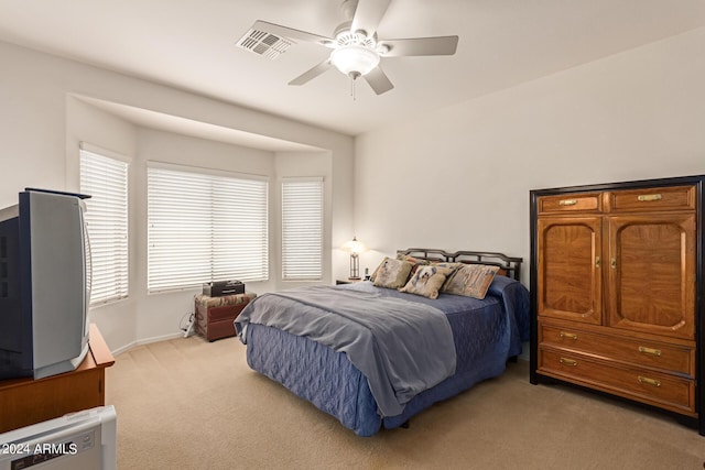 bedroom with ceiling fan, visible vents, and light colored carpet