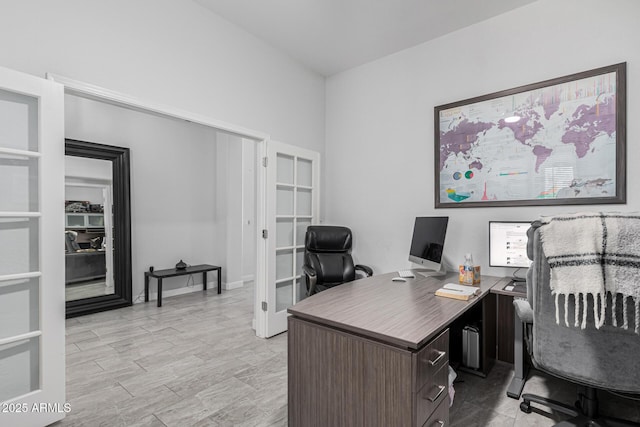 office area with light hardwood / wood-style floors and french doors