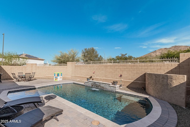 view of pool featuring a patio area, pool water feature, and a mountain view