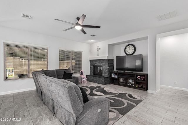 living room featuring ceiling fan and a fireplace