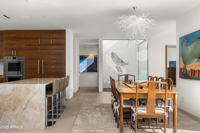 dining space with visible vents, a notable chandelier, and light tile patterned floors