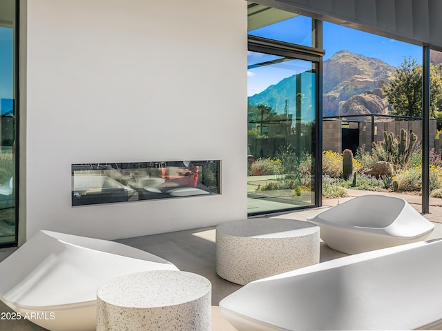 interior space featuring plenty of natural light, a mountain view, and a glass covered fireplace