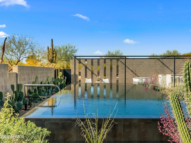 exterior space featuring a swimming pool and fence