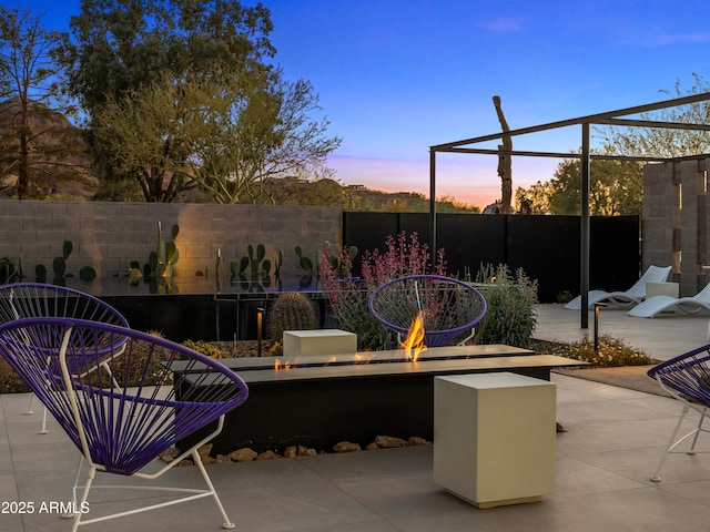 view of patio with an outdoor fire pit and fence