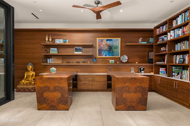 home office featuring light tile patterned floors, wood walls, and a ceiling fan