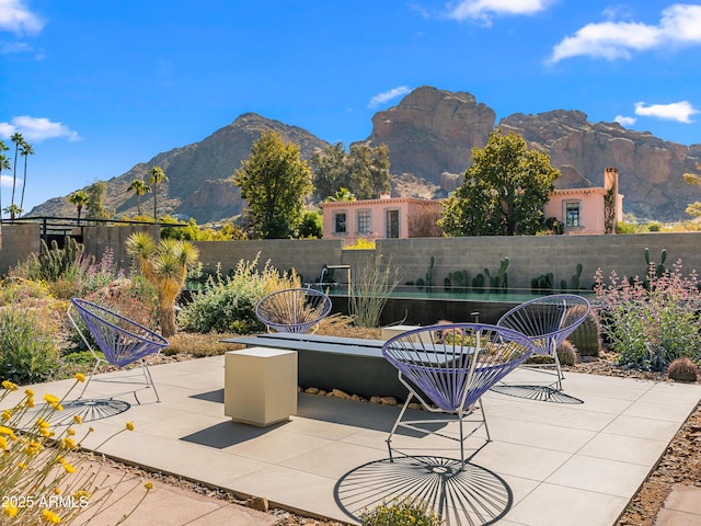 view of patio / terrace featuring fence and a mountain view