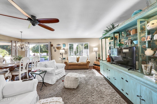 living room featuring ceiling fan with notable chandelier