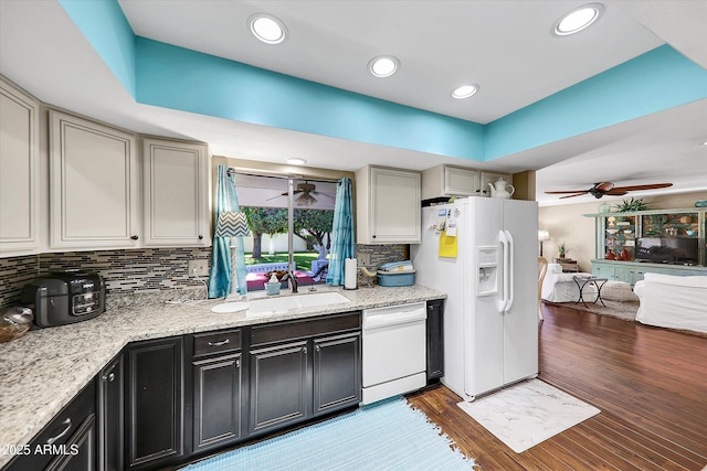 kitchen with white appliances, sink, ceiling fan, dark hardwood / wood-style flooring, and decorative backsplash