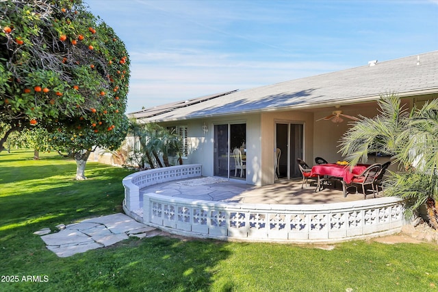 back of property with ceiling fan, a patio, and a lawn