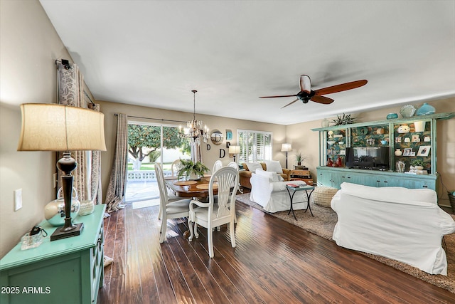 dining area with dark hardwood / wood-style flooring and ceiling fan with notable chandelier