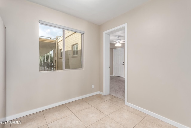 empty room with ceiling fan and light tile patterned flooring