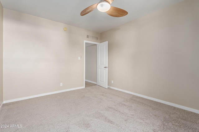 carpeted spare room featuring ceiling fan