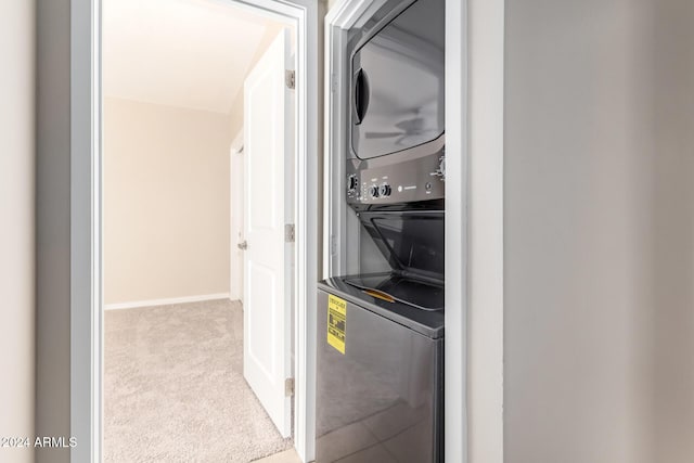 laundry area with stacked washing maching and dryer and light carpet