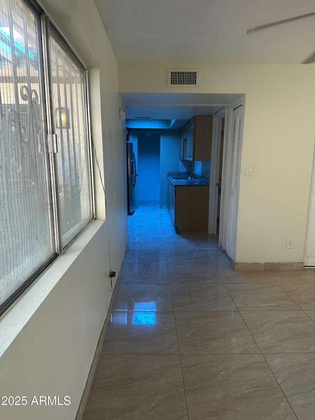 8110 N 31st Dr, Phoenix, AZ 85051 - hallway featuring plenty of natural light, light marble finish floors, and baseboards