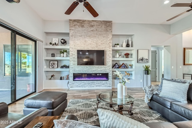 living room with built in features, a ceiling fan, and wood finished floors