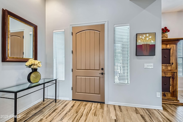 foyer entrance featuring light wood-style flooring and baseboards