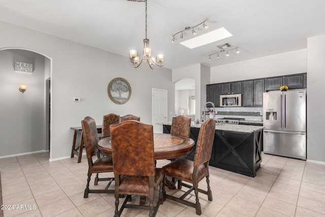 dining area with light tile patterned floors and an inviting chandelier