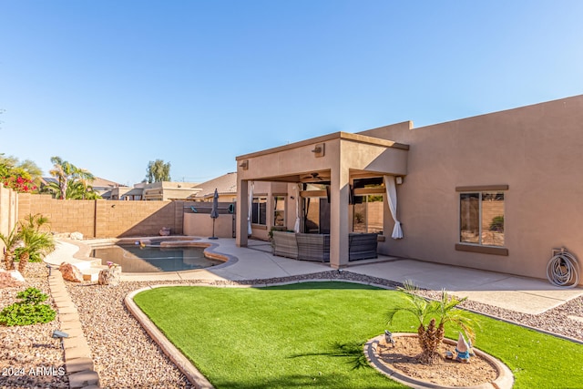 rear view of property featuring a swimming pool with hot tub, an outdoor hangout area, a patio, and ceiling fan