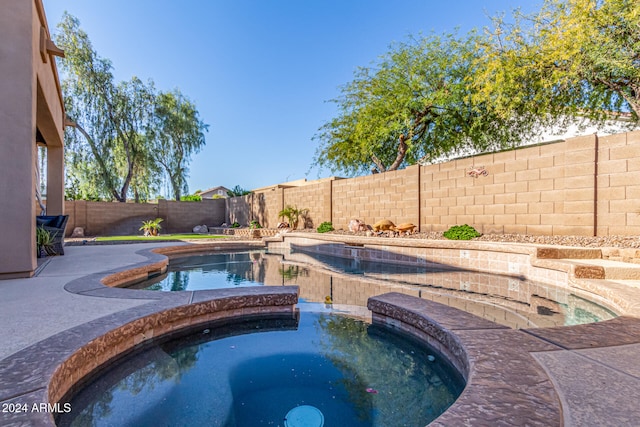 view of pool with an in ground hot tub