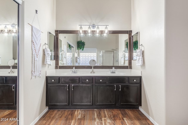 bathroom featuring hardwood / wood-style flooring, vanity, and a shower with door