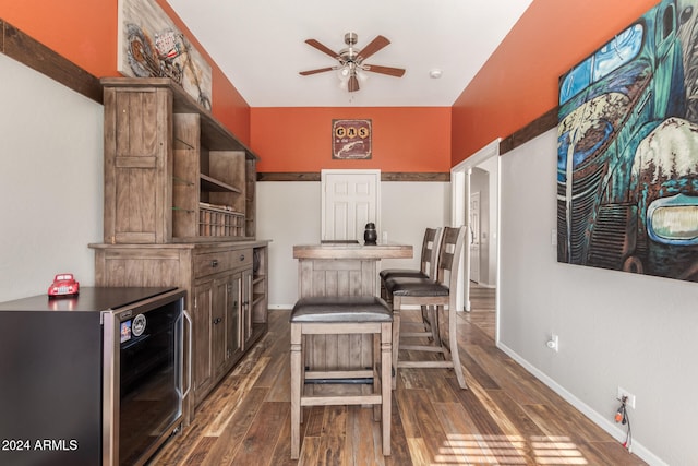 kitchen with a kitchen breakfast bar, wine cooler, dark hardwood / wood-style floors, ceiling fan, and dark brown cabinets