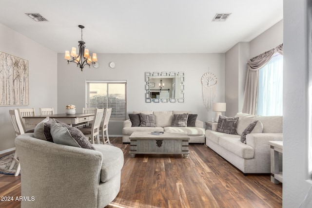 living room featuring a notable chandelier and dark wood-type flooring