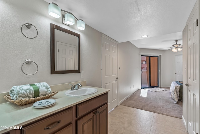 bathroom with a textured ceiling, tile patterned flooring, vanity, and ceiling fan