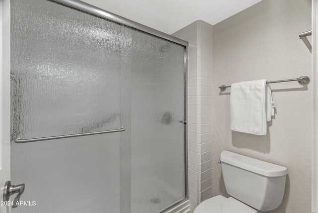 bathroom featuring an enclosed shower and toilet