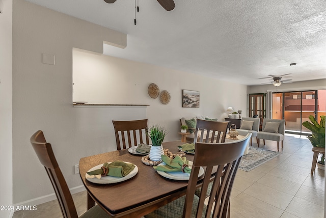 dining space featuring light tile patterned flooring, ceiling fan, and a textured ceiling