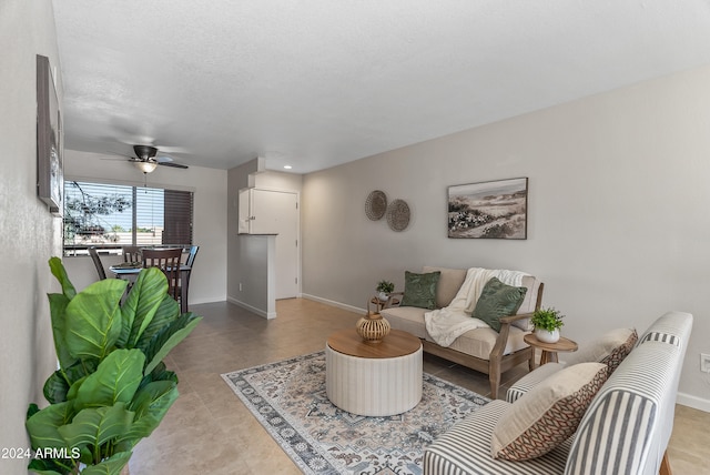 living room with a textured ceiling and ceiling fan