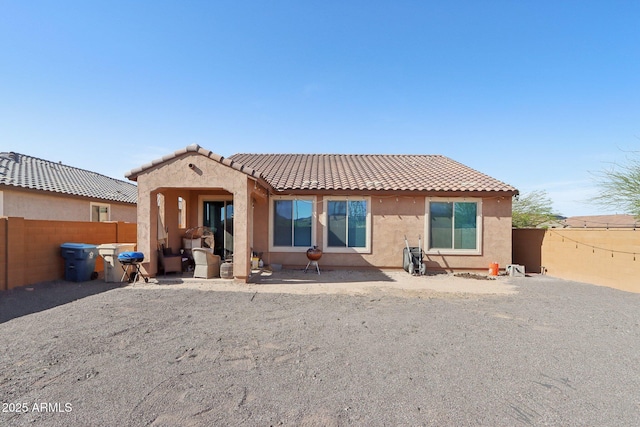 26049 W Matthew Dr, Buckeye, AZ 85396 - rear view of property featuring a tiled roof, a fenced backyard, and stucco siding