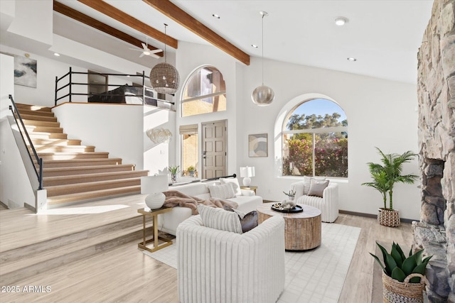 living room featuring a healthy amount of sunlight, beam ceiling, high vaulted ceiling, and light hardwood / wood-style flooring