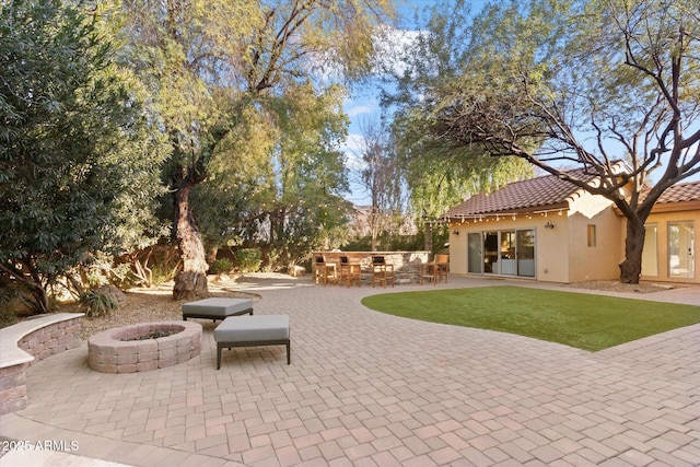 view of patio / terrace with an outdoor fire pit and exterior bar