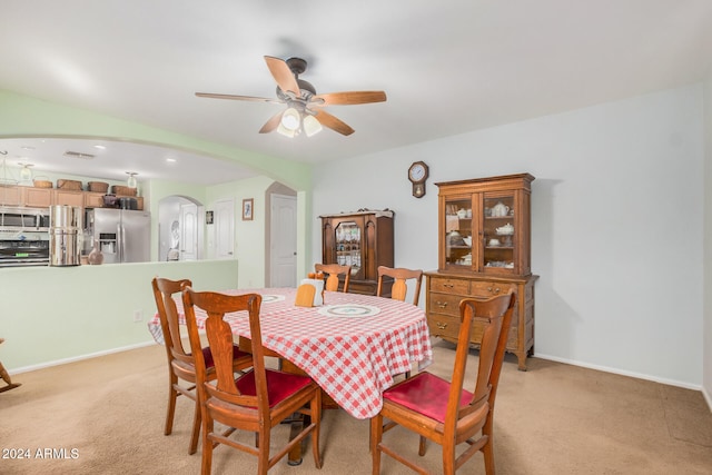 dining area featuring ceiling fan and light carpet