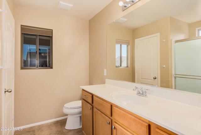 bathroom with tile patterned floors, vanity, toilet, and an enclosed shower