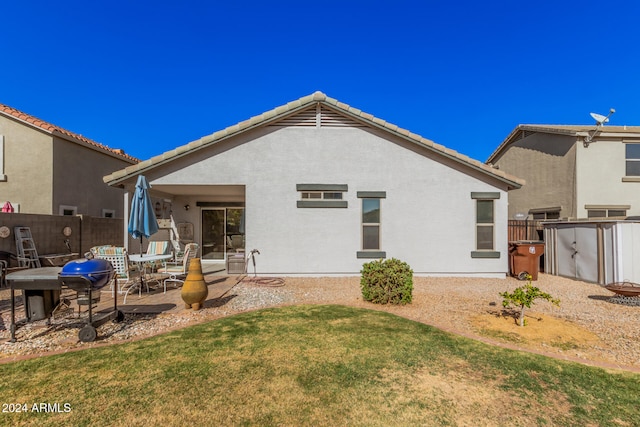 rear view of property featuring a yard and a patio