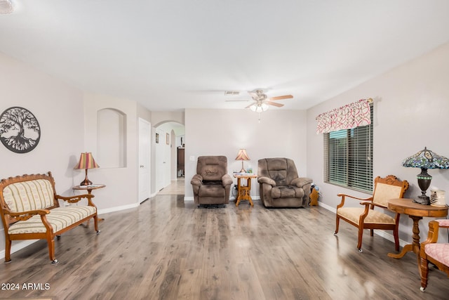 living area featuring hardwood / wood-style floors and ceiling fan