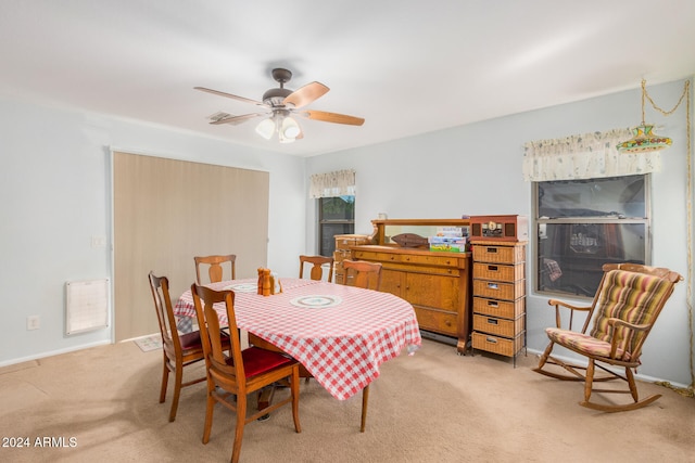 carpeted dining space with ceiling fan