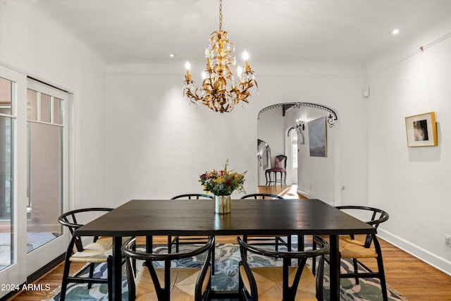 dining area with hardwood / wood-style floors and a chandelier