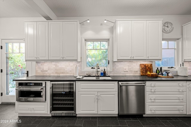 kitchen featuring white cabinets, stainless steel oven, sink, and wine cooler