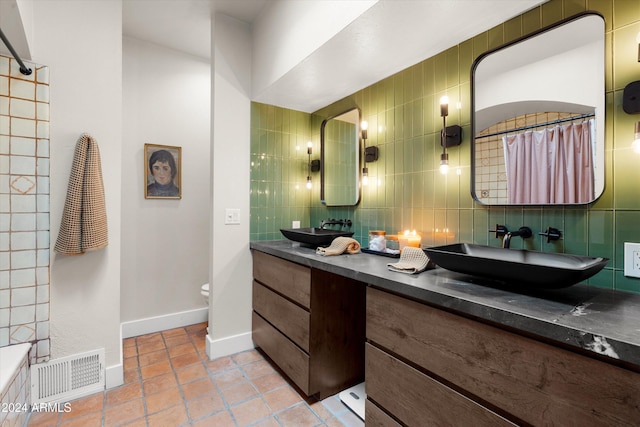 bathroom with backsplash, tile patterned flooring, vanity, and tile walls