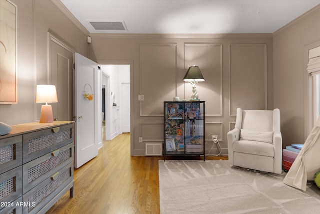 sitting room featuring light hardwood / wood-style floors and crown molding