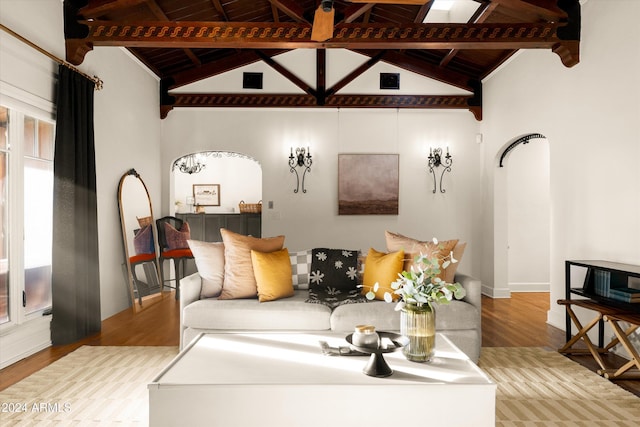 living room with vaulted ceiling with beams, a healthy amount of sunlight, wood-type flooring, and wooden ceiling