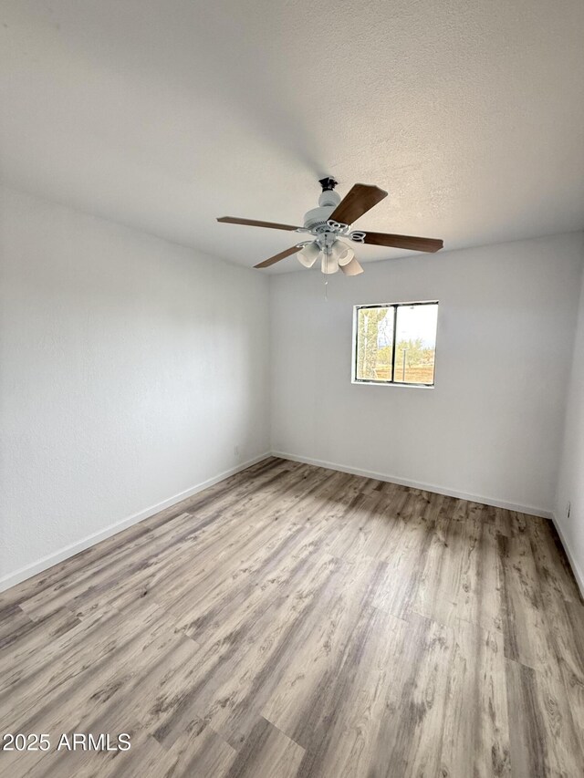 1020 W Schwartz Rd, Ajo, AZ 85321 - unfurnished room featuring a textured ceiling, wood finished floors, baseboards, and ceiling fan